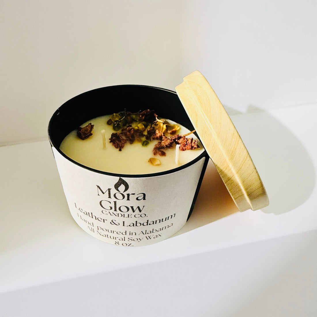 Leather & Labdanum soy wax candle in a black tin vessel, warm and masculine home fragrance.